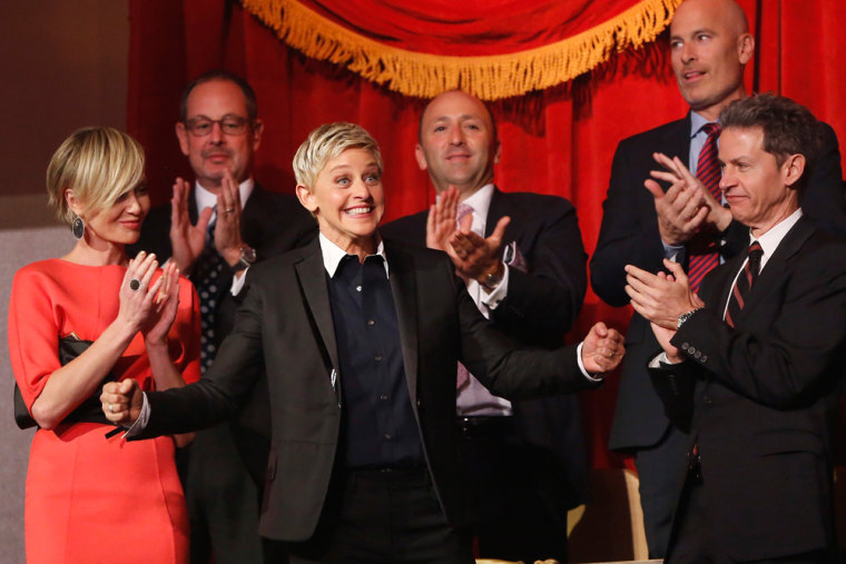 Image: DeGeneres smiles as her family and friends, including de Rossi, applaud her entrance at the Mark Twain Prize ceremony in Washington